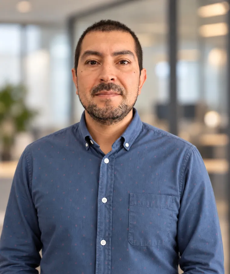 Retrato de Fabián Velásquez, con camisa azul, en una oficina
